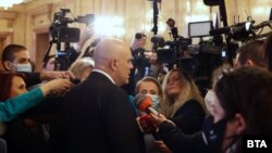 Главният прокурор Иван Гешев в сградата на Народното събрание минути преди началото на процедурата по гласуване на новия кабинет. Там той се засече с президента Румен Радев.