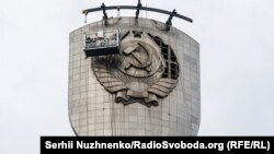 Під час демонтажу герба СРСР зі щита монумента «Батьківщина-мати», замість якого встановлять Тризуб – герб України. Київ, 30 липня 2023 року 