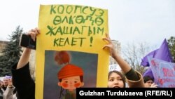 Участницы женского марша в Бишкеке. 8 марта 2024 года. (Надпись на плакате: "Хочу жить в безопасной стране"). 