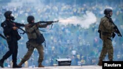 Forțele de securitate acționează în Piața celor Trei Puteri, în timp ce susținătorii fostului președinte brazilian Jair Bolsonaro demonstrează violent împotriva președintelui Luiz Inacio Lula da Silva, Brasilia, Brazilia, 8 ianuarie 2023.