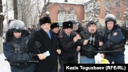 Полиция задерживает участников акции протеста против действия властей в Жанаозене, среди них политик Хасен Кожа-Ахмет (второй слева). Алматы, 17 декабря 2011 года. 
