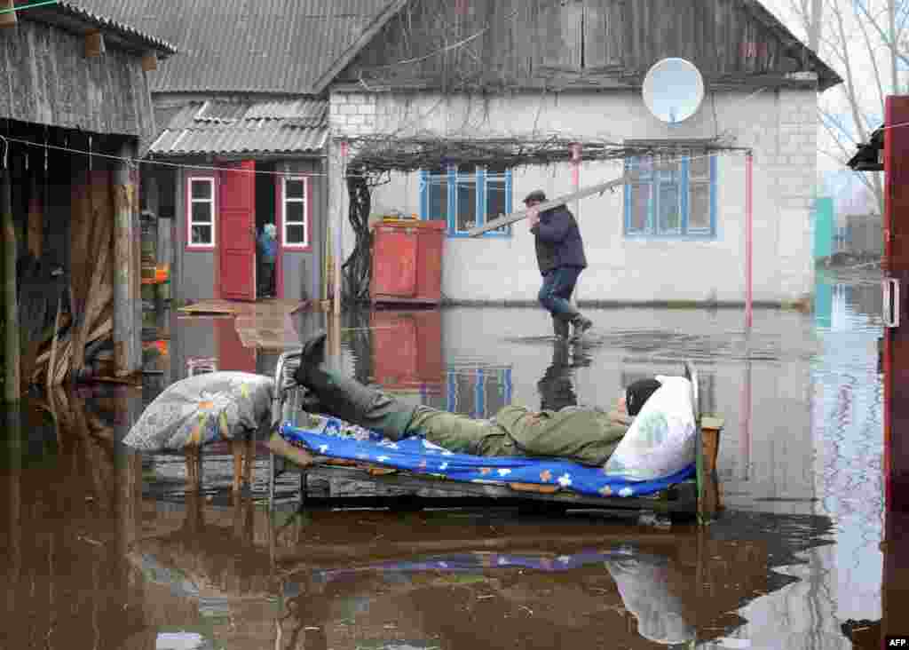 Білорусь &ndash; чоловік лежить на ліжку під час весняного паводку в селі Хвоєнськ, 14 квітня 2013 року