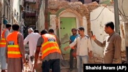Pakistani volunteers collect debris from a demolished Ahmadi mosque in the eastern city of Sialkot on May 24.
