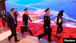 În timpul recentei vizite în China a președintelui rus Vladimir Putin, reporterii au reușit să „prindă” ceva ce se vede în public mai rar: „valiza nucleară”. În fotografia Reuters, doi ofițeri ai marinei rusești duc două asemenea valize, pășind în urma lui Putin. 