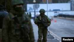 Bărbați înarmați patrulează la aeroprotul in SImferopol, Crimeea, 28 februarie 2014
