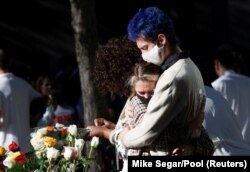 People embrace at the 9/11 Memorial on the 20th anniversary of the September 11 attacks in Manhattan, New York City, U.S., September 11, 2021.