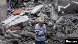 Un bărbat merge printre dărâmăturile unei clădiri pe 8 mai, după un atac aerian al Rusiei asupra Kostiantinivka.
