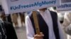 A man holds a banner during a demonstration in Kabul demanding the release of frozen Afghan funds. (file photo)