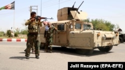 Afghan security personnel guard a checkpoint in the Guzara district in Herat on July 30.