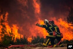 A franciaországi Gironde régió tűzoltói küzdenek a lángokkal egy erdőtűznél a délnyugaton fekvő La Teste-de-Buchban 2022. július 18-án