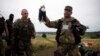 Бойовик угруповання «ДНР» тримає дитячу іграшку на місці катастрофи «Боїнга-777», Грабово, Донецька область, липень 2014 року