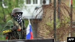 Separatist mascat păzind o clădire în Donețk, vineri 9 mai, 2014