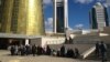 Полицейские наблюдают за собравшимися "ипотечниками" у правительственных зданий в Астане. 2 октября 2013 года.
