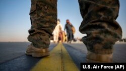 A U.S. Marine provides security for evacuees boarding a U.S. Air Force plane at Hamid Karzai International Airport in Kabul on August 24.