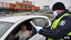 Полицай проверява деклаация на шофьорка на КПП на един от изходите от Хасково