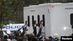 Fotožurnalistler Julian Assanjy alyp barýan polis ulagynyň içini surata düşüryärler. London, 7-nji dekabr, 2010.